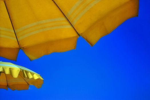 Yellow  umbrellas against clear blu summer sky