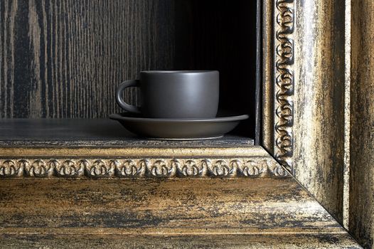 Black cup on a shelf in the form of a frame