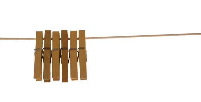 Wooden pegs hanging from a rope against white background