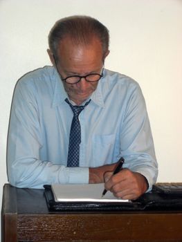 A business man is scribbling in his notepad.