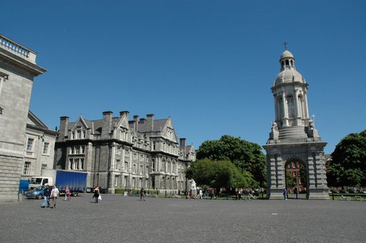 Wide angle shot of the Quad in Trinity College Dublin with the beautiful Bell tower to the right against a bright blue sky