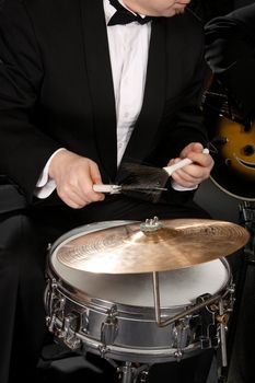 The musician plays a drum with a plate
