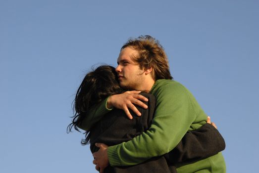 young couple with the sky as background