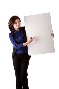 Happy smiling beautiful young caucasian brunette business student woman standing next to and holding a white blank board and pointing at it, isolated