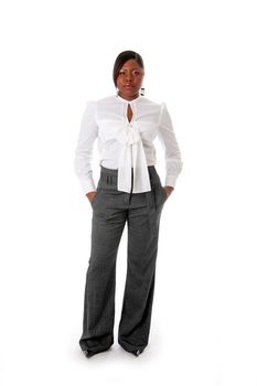 Beautiful African American business woman with attitude dressed in a white shirt and gray pants standing, hands in pocket, isolated