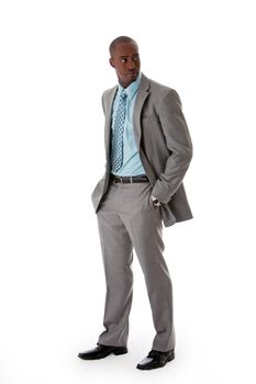 Handsome African American man in gray suit with smile standing with hands in pocket, isolated