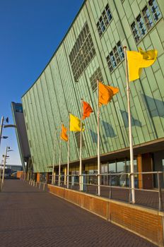 Colored flags in the background of a copper facade. Blowing in the wind. Urban space.