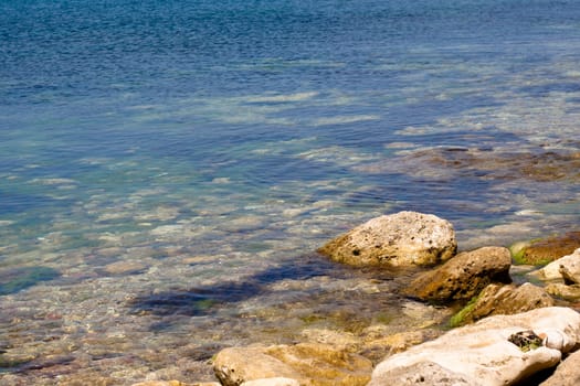 Crimea coast in summertime: stones in water
