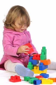 beauty a little girl with colorful blocks on white background