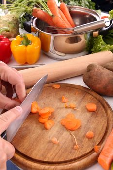 chef cutting carrots on a cutting board