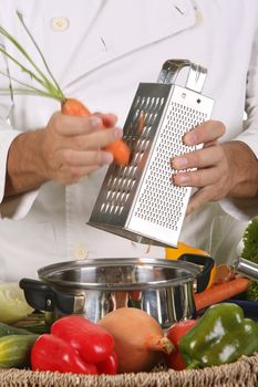 cutting carrot with stainless grater in motion