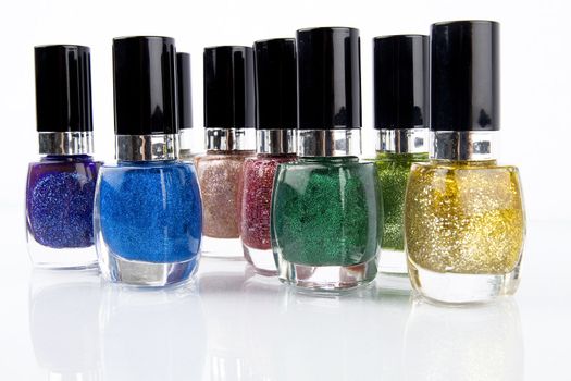 Group of nail polishes of different colors on white background