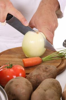 chef preparing lunch and cutting onion with knife