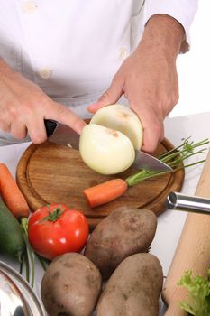 chef preparing lunch and cutting onion with knife