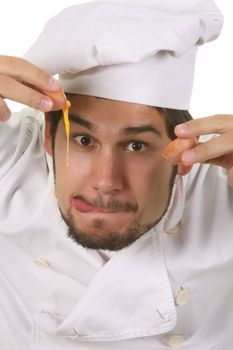 young funny chef cracking an egg, isolated on white