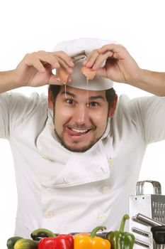 young funny chef cracking an egg, isolated on white