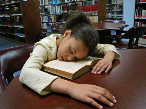 Girl Reading herself to sleep in the library