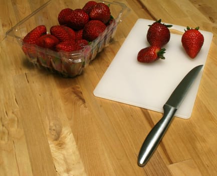 Strawberries on cutting board with knife