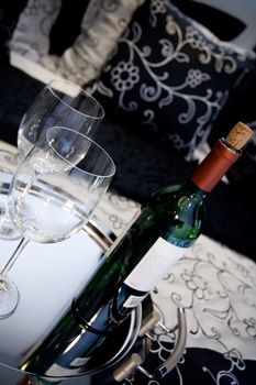 conceptual image of a bottle of wine and two glasses on the bed 