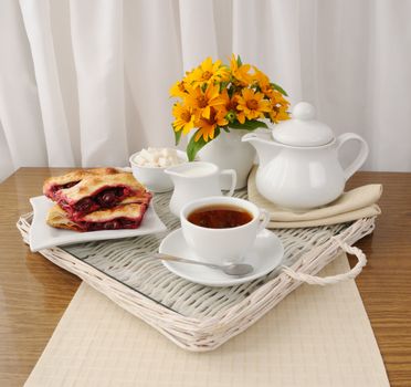 Breakfast with the cherry strudel with tea and milk on a tray