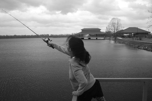 girl fishing from pier