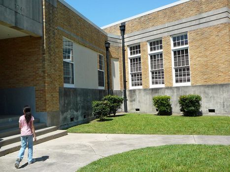 Girl walking into school building