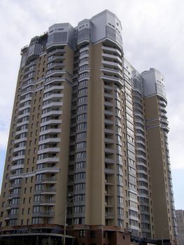 high building is abutted by roof against sky. 