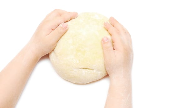 Child's hands kneading dough on white