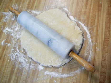 Dough on board with rolling pin