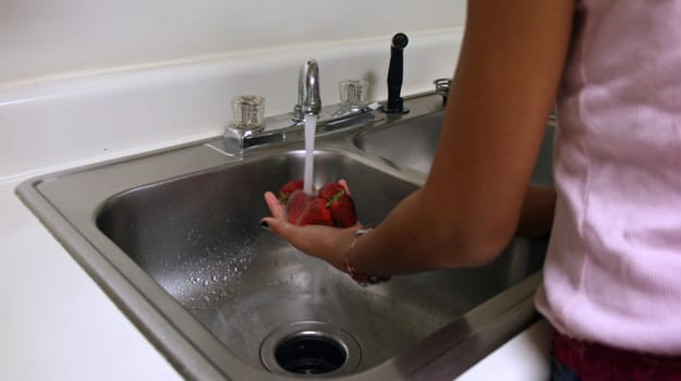 Strawberries under a stream of water