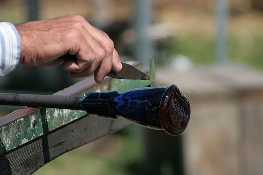 Glass-blower works over a new vase.