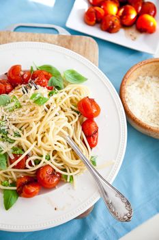 Plate filled with spaghetti, crushed tomatoes, basil and parmezan