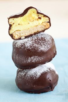 Chocolate covered marshmallow cookies stacked with three (focus on top cookie)