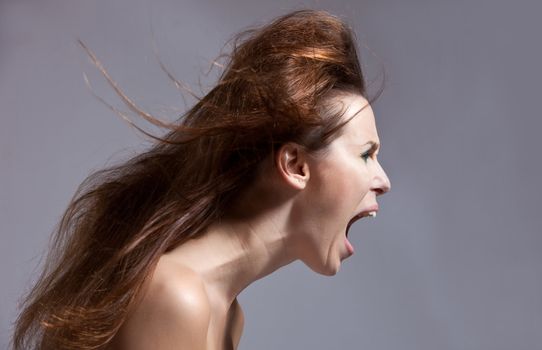 Woman with wild hairstyle screaming at the top of her lungs