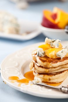 Small pancakes with blue cheese, fruit and honey