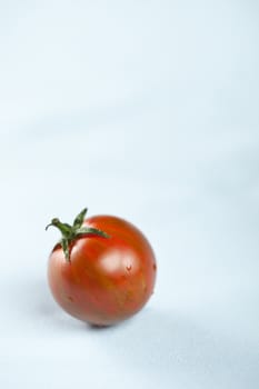 Small ripe tiger tomatoe on table surface