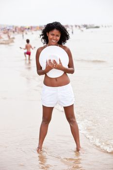 Beautiful brazilian girl on the beach near the waterfront