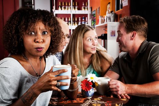 Shocked Pretty African American Woman in Coffee House with Friends