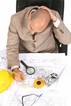 Businessman thinking with architectural plans on white background