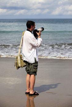 The photographer with a camera at coast