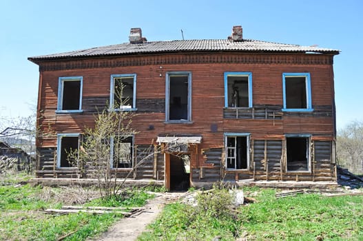 Facade of old destroyed two-storeyed wooden house