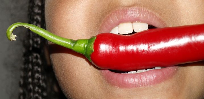 closeup girls mouth with chilli