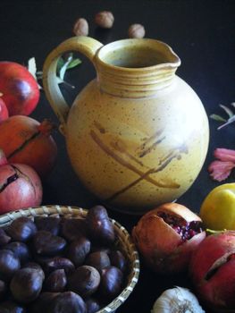 A water jug surrounded with fruits on a dark background.