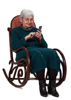 Image of a senior woman siting in a rocker and writing a phone message.