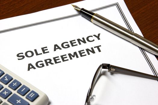 Image of a sole agency agreement on an office table.