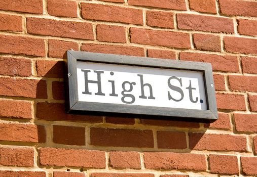Ancient road sign showing High St in wooden frame