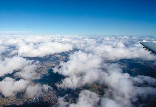 View from aircraft of the clouds and sunlit land below