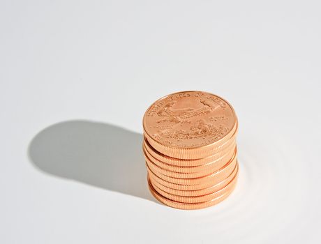 One Ounce gold eagle coins in a stack of ten with a shadow