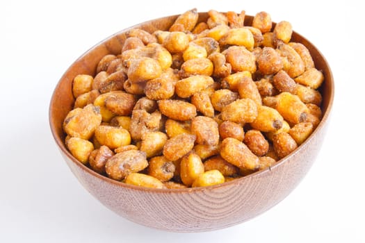 A cherry wood bowl of shelled peanuts on a white background.