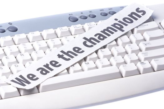 Image of a newspaper cutting with the words "We are the Champions" placed on a computer keyboard.